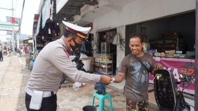 
					Edukasi, Satlantas Polres Pandeglang Pasang Stiker dan Bagikan Masker