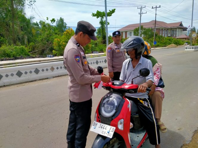 Personel Polres Tanjabbar Bagikan Bendera Merah Putih, Bangkitkan Nasionalisme Bagi Masyarakat